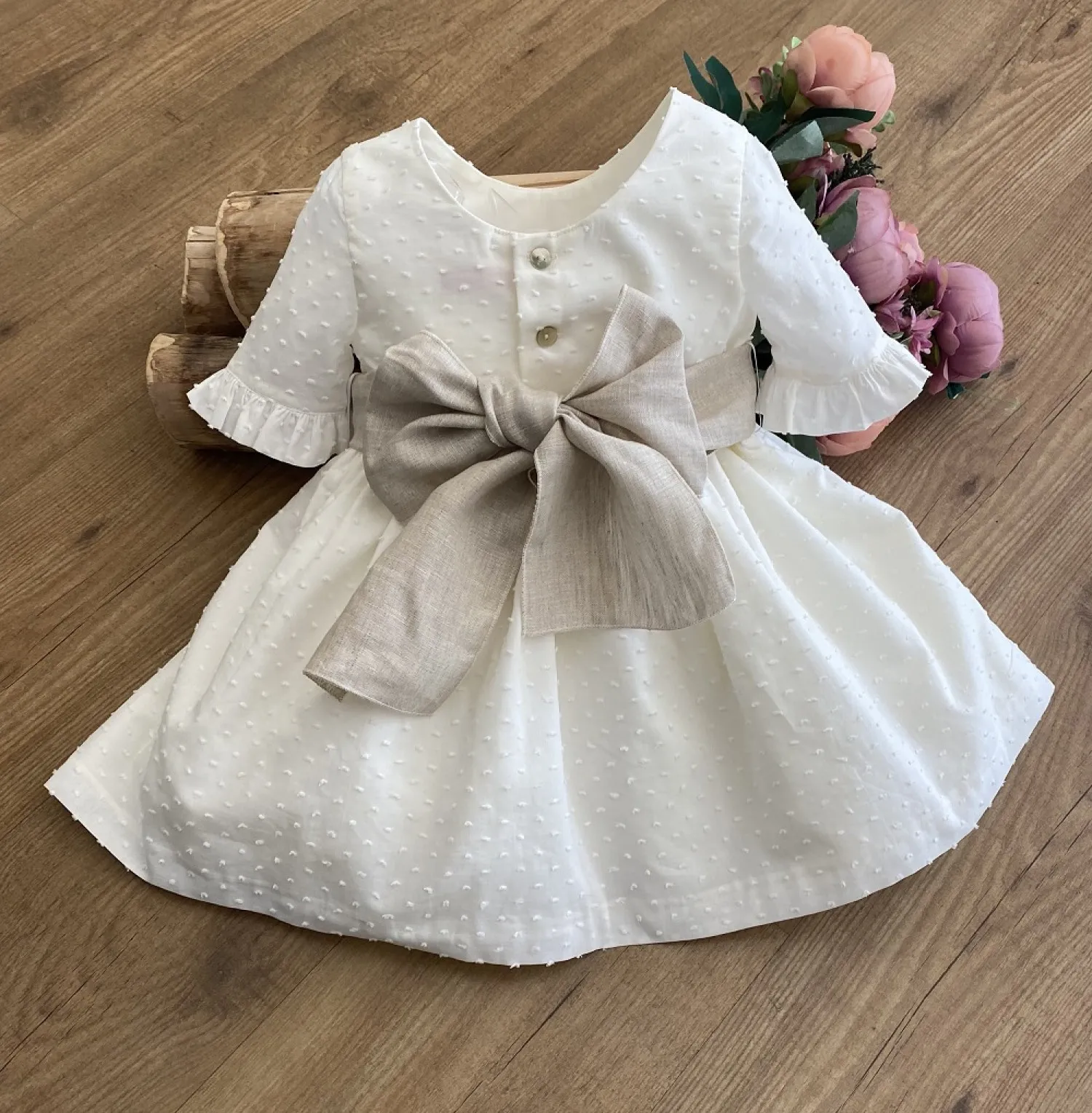 Ecru plumeti flower dress with sand linen bow.